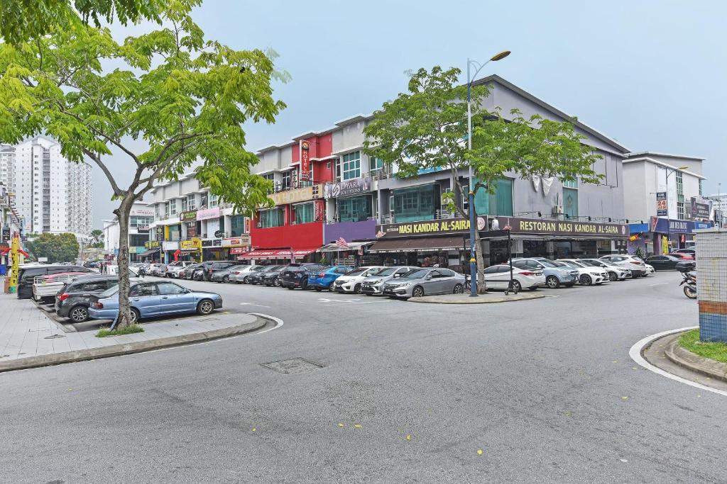 une rue de la ville avec des voitures garées devant les bâtiments dans l'établissement OYO 90853 New Soho Hotel, à Batu Caves
