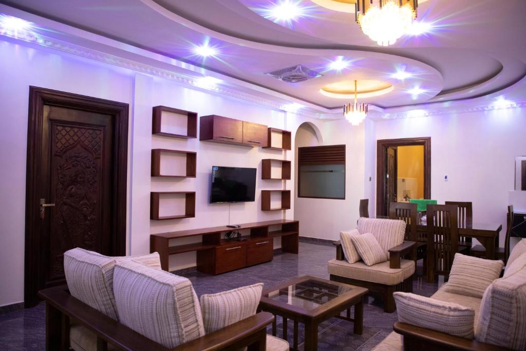 uma sala de estar com cadeiras, uma televisão e uma mesa em WIMAL PALACE em Jaffna