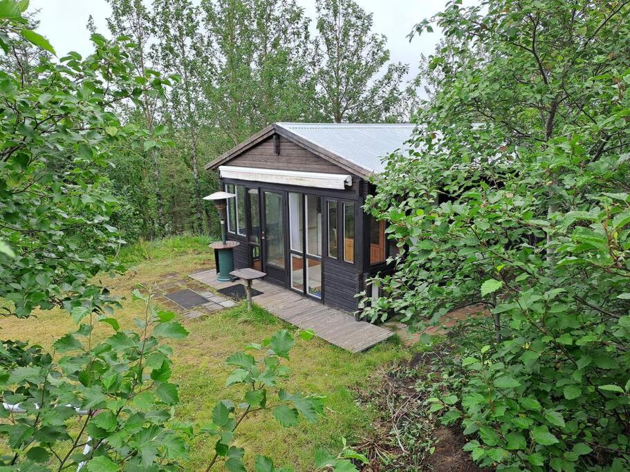 una pequeña cabaña en medio de un bosque en Cozy cottage in the south, en Keldur