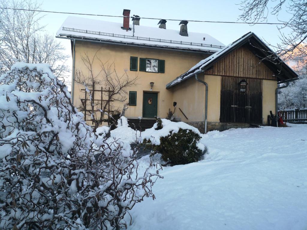 une maison avec de la neige devant elle dans l'établissement Ferienwohnung im alten Zollhaus, à Dellach