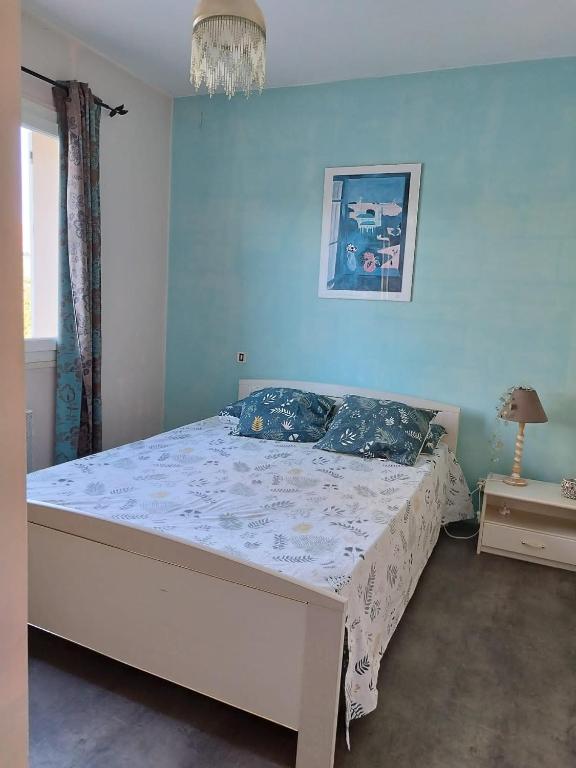 a bed in a bedroom with a blue wall at Chambre in Montech