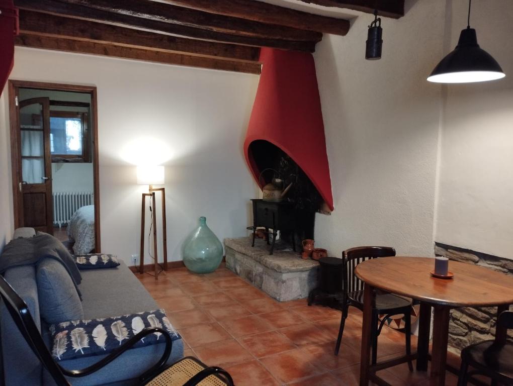 een woonkamer met een bank en een open haard bij Llar compartida El Tupí in Sant Juliá de Vilatorta