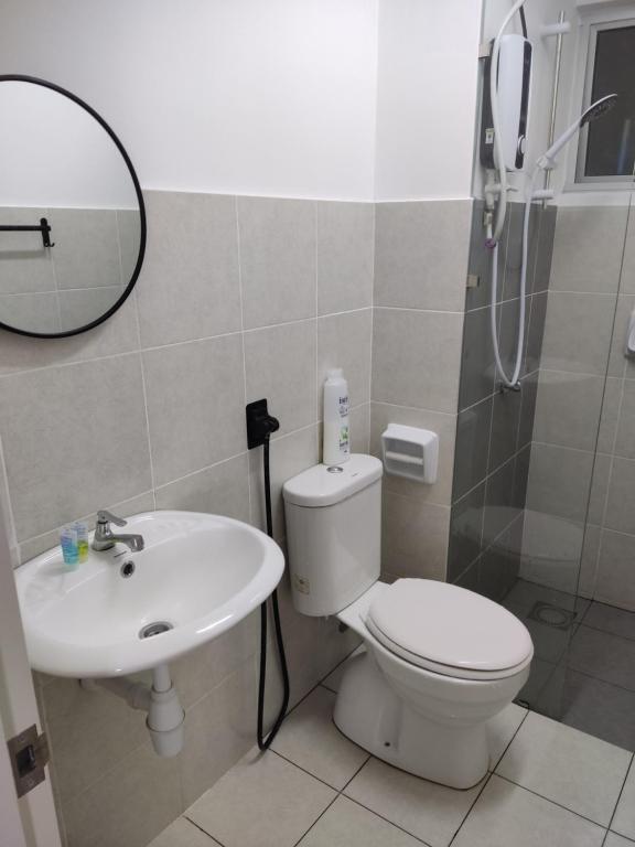 a bathroom with a toilet and a sink and a mirror at FA Homestay Alanis, Near KLIA in Sepang