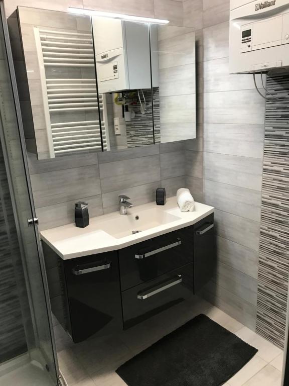 a bathroom with a sink and a mirror at Cosmopolitan Apartman in Sárospatak