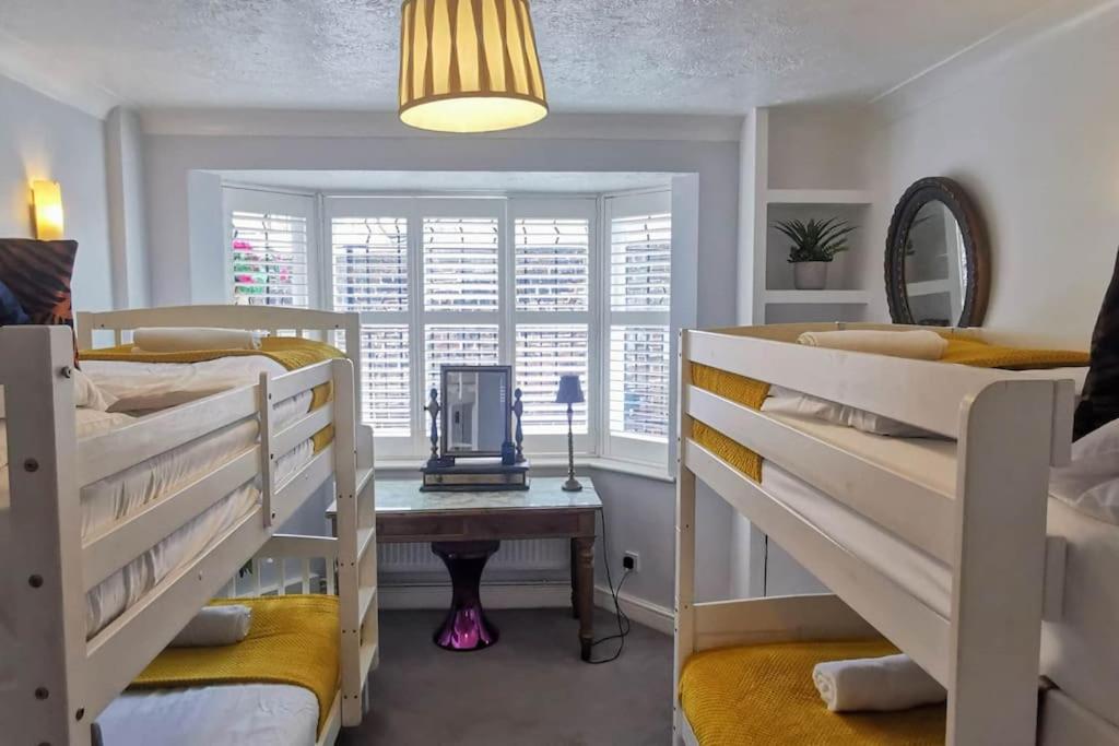 um quarto com 3 beliches e uma janela em Brighton Parlourama with Hot Tub - Sleeps 18 em Brighton & Hove
