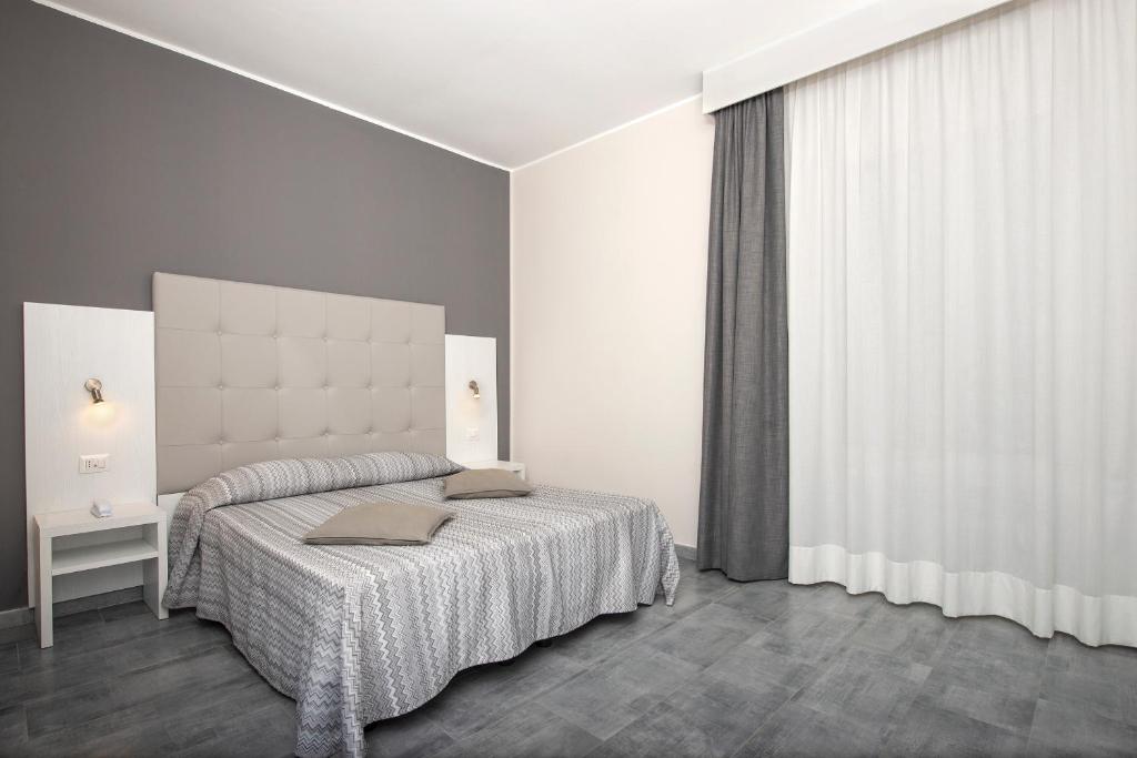 a bedroom with a bed and a large window at Hotel Assarotti in Genoa