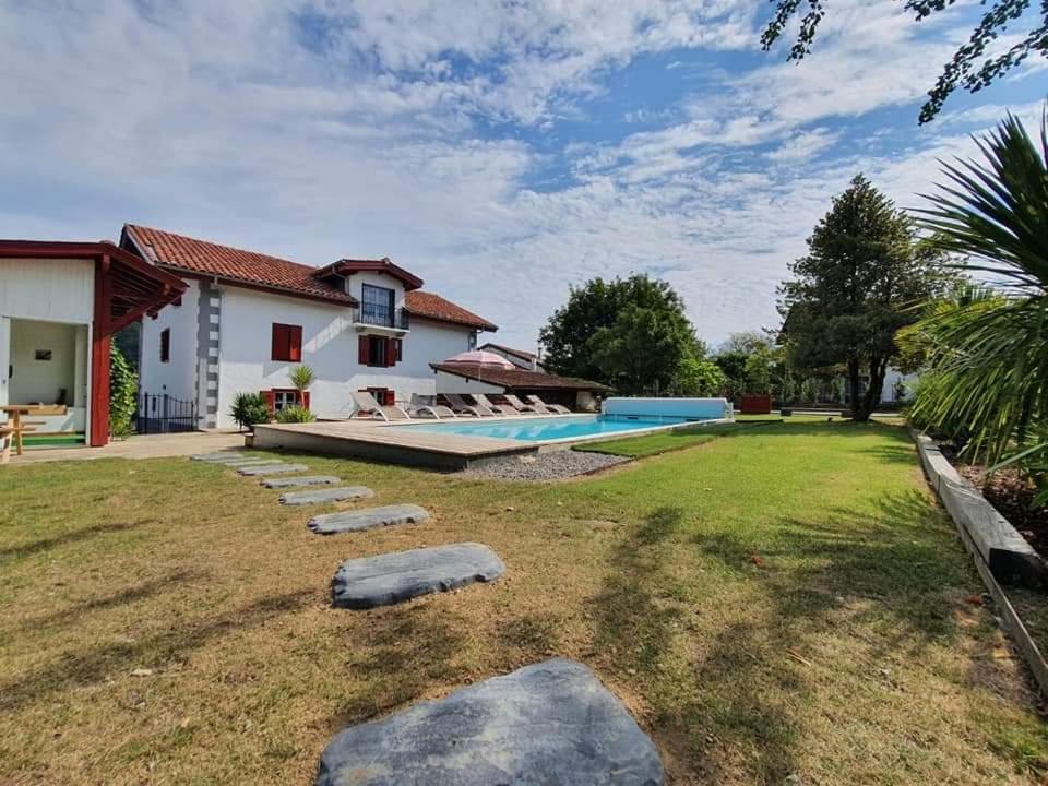 une cour arrière avec une piscine et une maison dans l'établissement Maison Basque (24 pers), à Ascarat