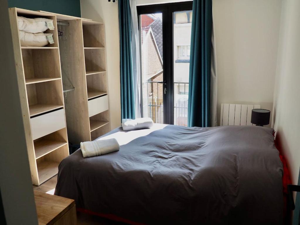 een slaapkamer met een bed, een raam en een boekenplank bij Belle Villa au Coeur du Touquet in Le Touquet-Paris-Plage