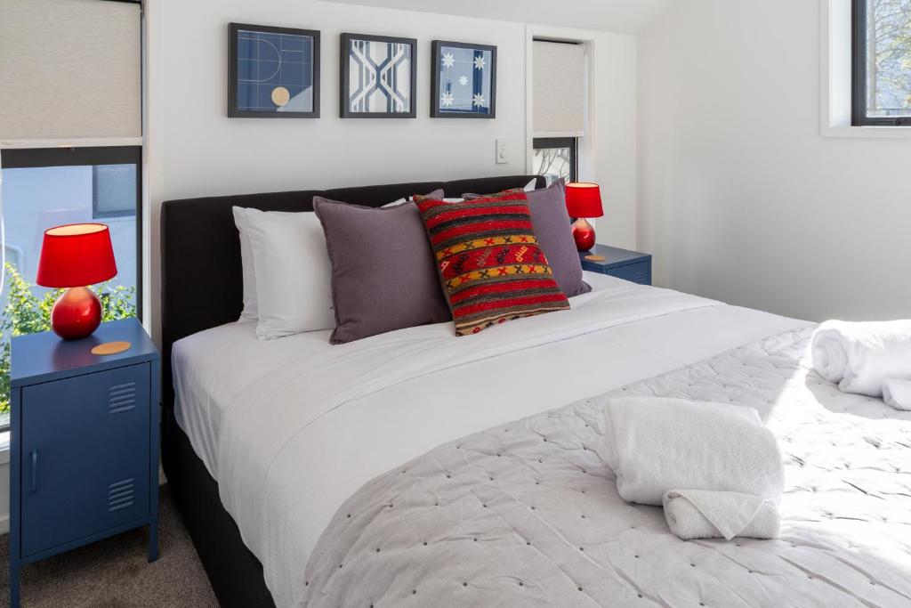 a bedroom with a large white bed and two blue night stands at Central City Escape 1 Bed 1 Bath near Hagley Park in Christchurch