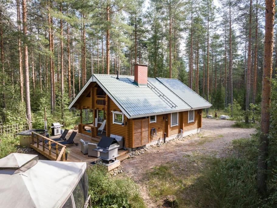 a wooden cabin in the middle of a forest at Cottage with Hot tub and Sauna in Uurainen