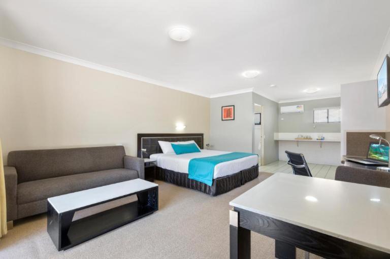 ブリスベンにあるComfort Inn North Brisbaneのベッドとソファ付きのホテルルーム