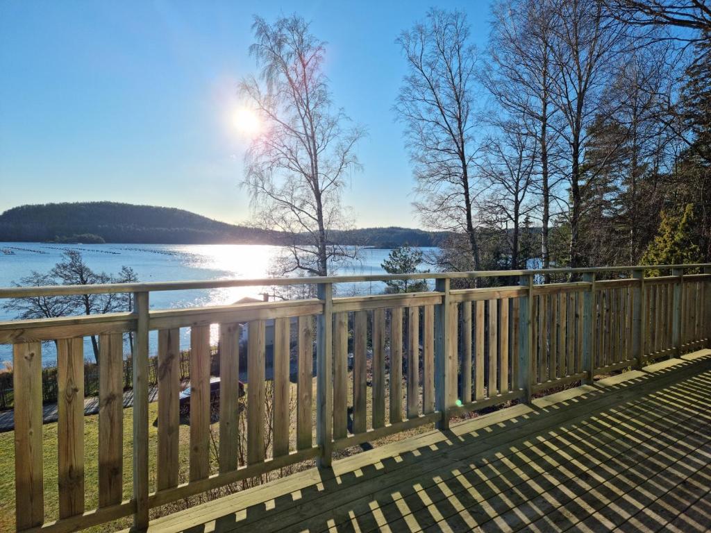 a wooden fence with a view of the water at Sandy Beach Cottage in Uddevalla