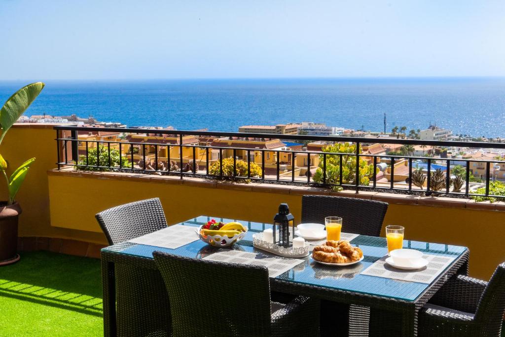 Una mesa en un balcón con vista al mar. en Belvedere Penthouse, en Puerto de Santiago