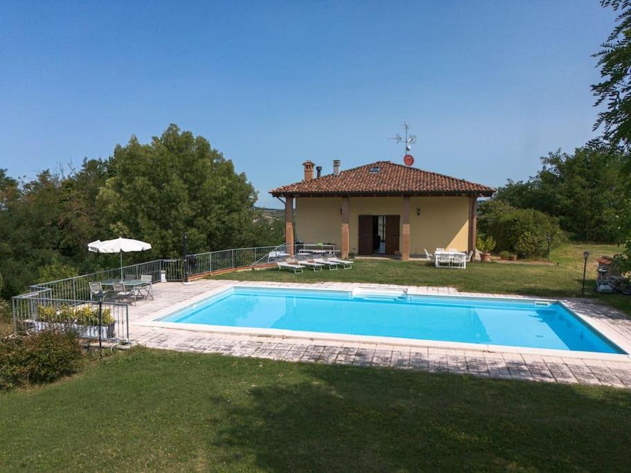 a swimming pool in front of a house at CASOLARA: ospitalità su misura in Castello di Serravalle