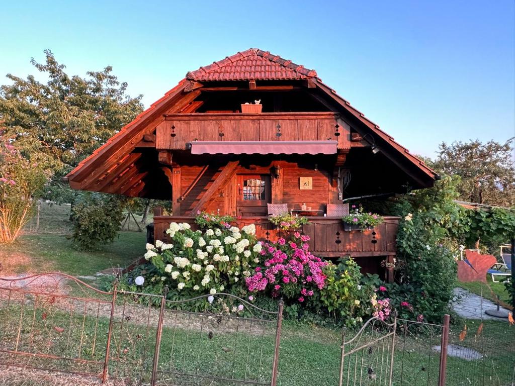 een klein houten huis met bloemen in de tuin bij Hadassa Apartment Mutzli in Steffisburg