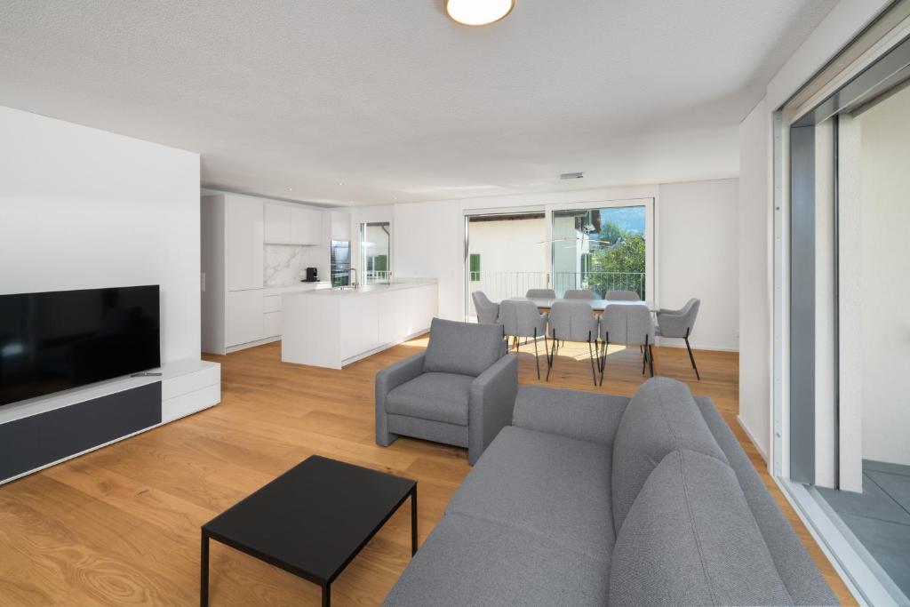 - un salon avec un canapé gris et une table dans l'établissement Neubauwohnung mit Lift in Matten, à Matten
