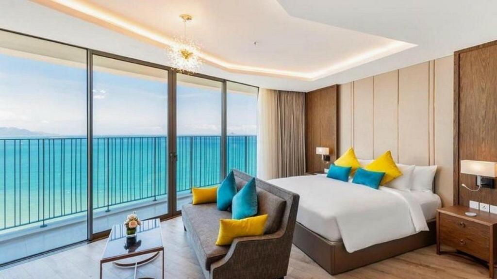a hotel room with a bed and a large window at SeaScape Panorama Grand Resicedences Nha Trang in Nha Trang