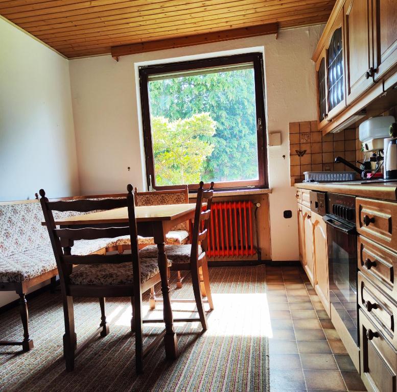 een keuken met een houten tafel en een raam bij Großes Haus in Petersfehn I in Bad Zwischenahn