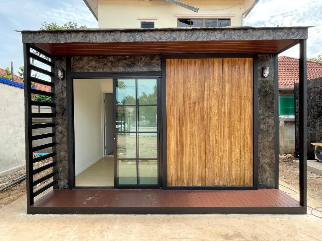 ein kleines Haus mit einer großen Tür in der Unterkunft Piyaporn Guesthouse in Khon Kaen