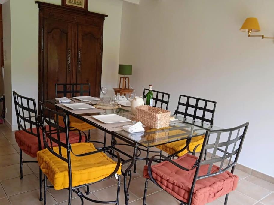 une salle à manger avec une table et des chaises en verre dans l'établissement Cottage spacieux Domaine de la Bretesche, à Missillac