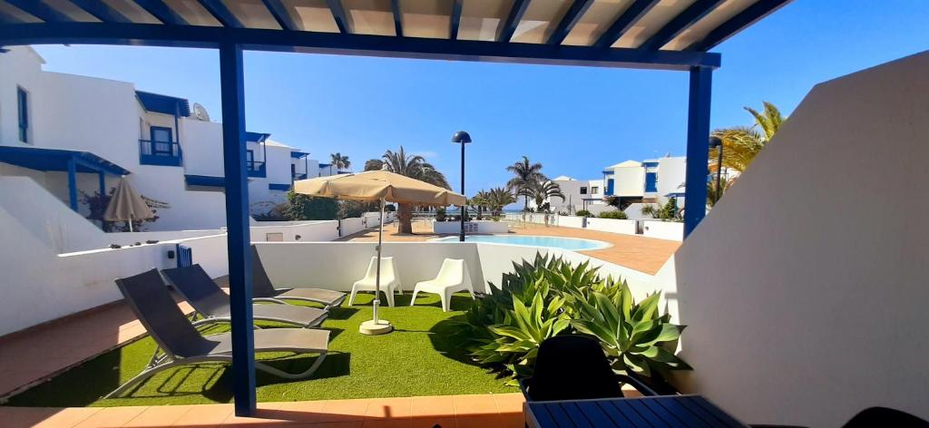 Elle offre une vue sur une terrasse avec des chaises et une piscine. dans l'établissement Villa Suculenta, à Playa Blanca