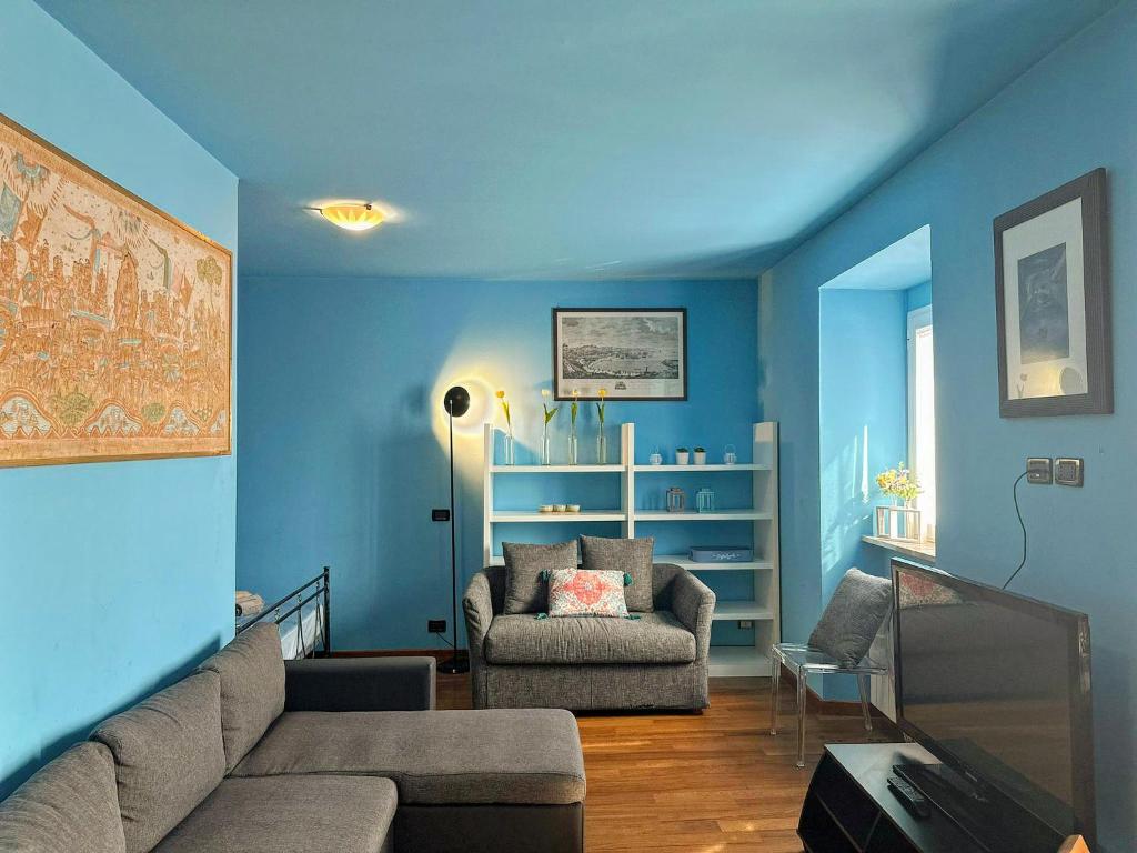 een blauwe woonkamer met een bank en een stoel bij Charlotte Deluxe Apartment 2 in Trieste