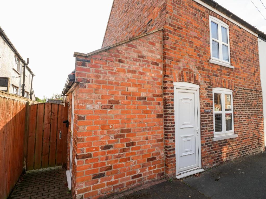 um edifício de tijolos vermelhos com uma porta branca em 4 Lynton Cottages em Hull