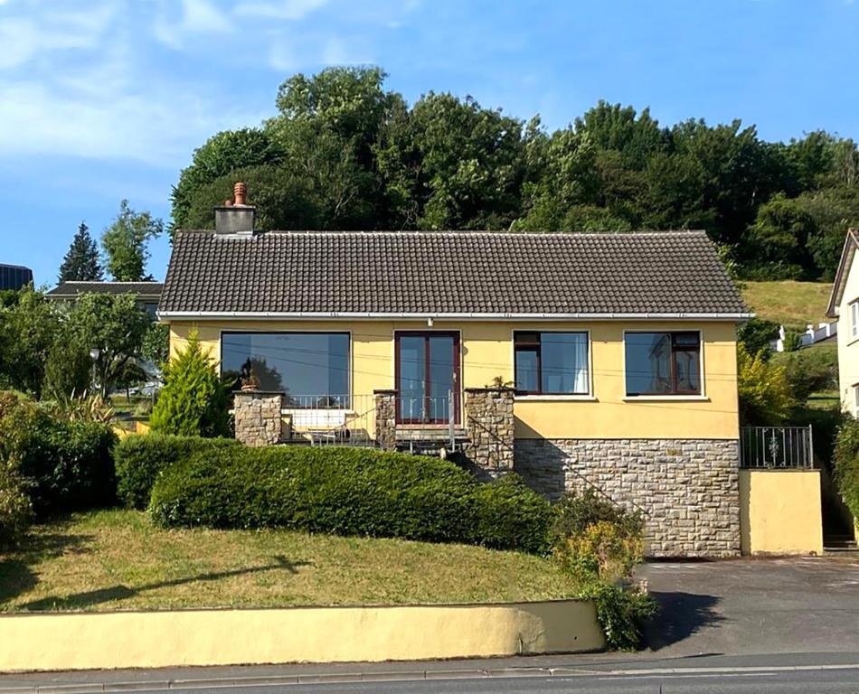 uma casa amarela com um telhado castanho em Donegal Town House em Donegal
