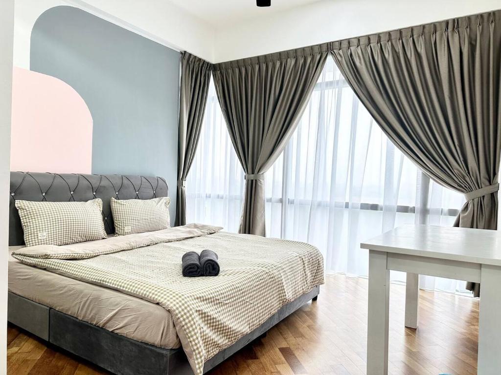 een slaapkamer met een bed met twee zwarte schoenen erop bij A1601 Grand Medini 2BR 100mbps Netflix By STAY in Nusajaya