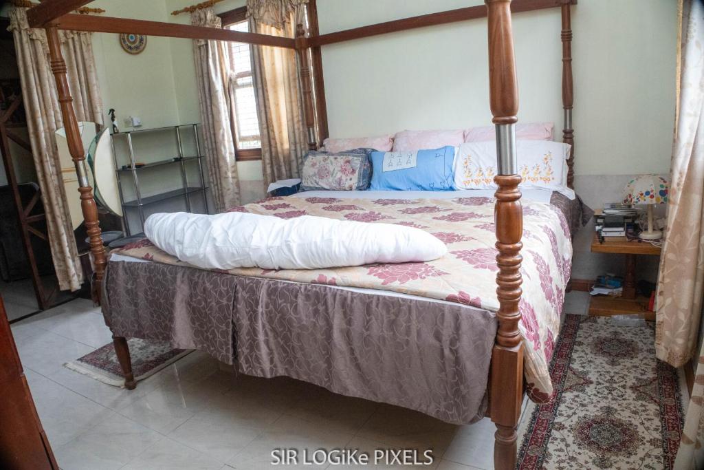 1 dormitorio con 1 cama con marco de madera en Art and Leisure-EB Hotel, en Takoradi