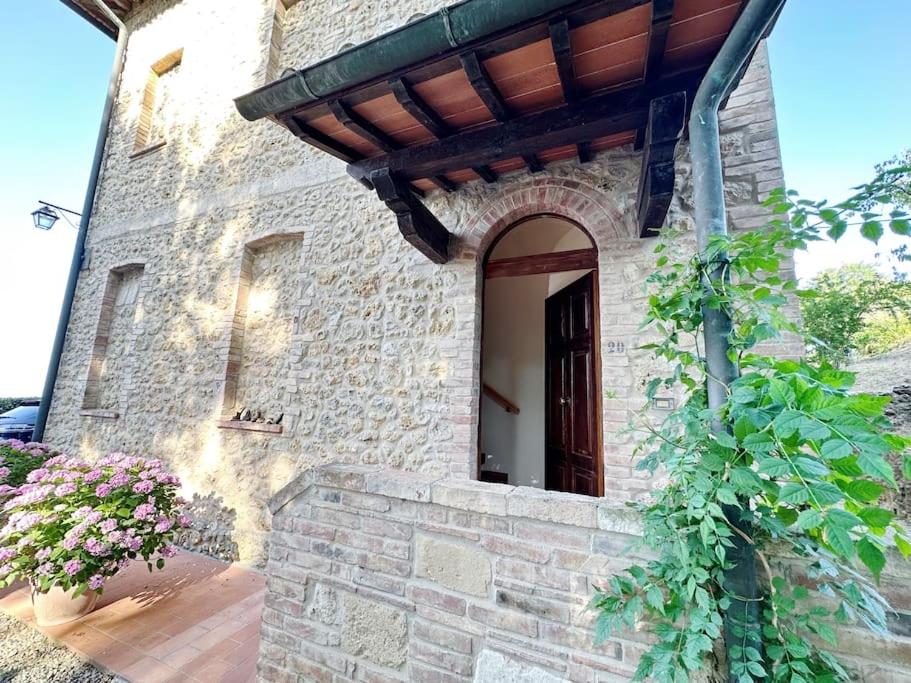 a stone building with a window and a door at Casale di Valle Mora in San Gimignano