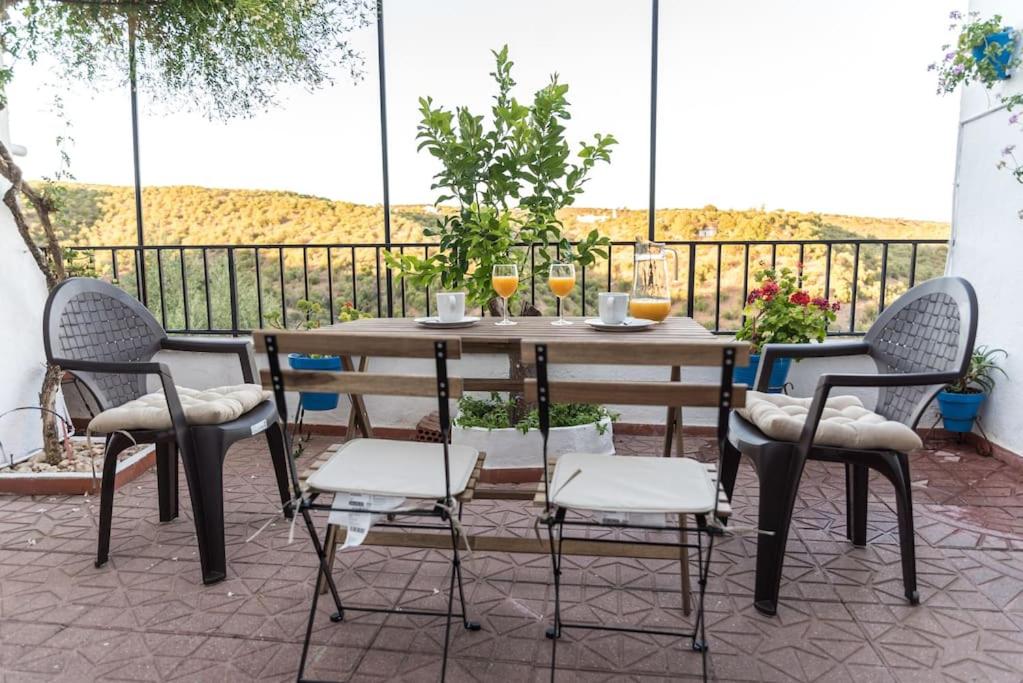 een houten tafel en 4 stoelen op een patio bij Casa céntrica con vistas a la sierra in Hornachuelos