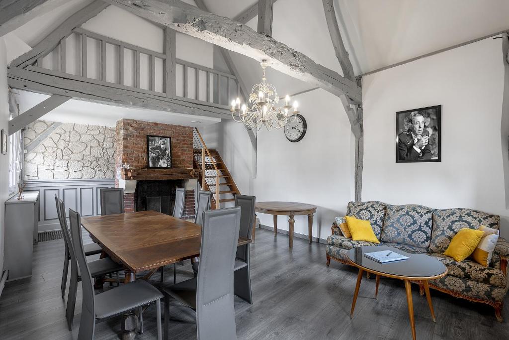 a dining room and living room with a table and a couch at Chambres d'hôte - Clos d'Allonne in Beauvais