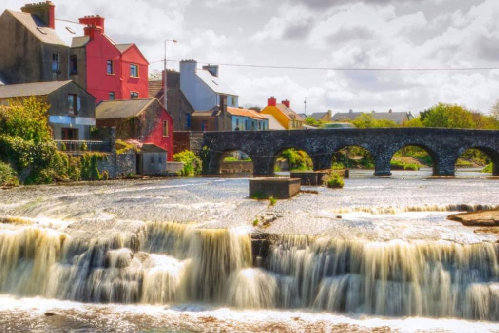 einen Fluss mit einer Brücke und einem Wasserfall in der Unterkunft Perfect Apartment in ideal location in Ennistymon