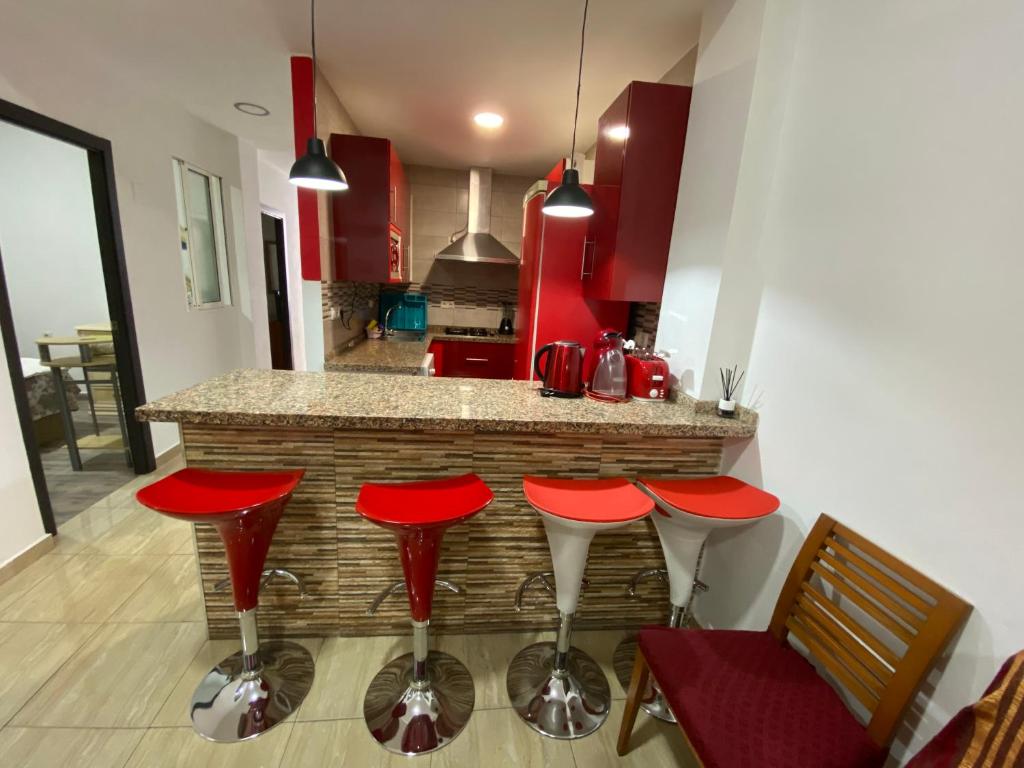 een keuken met rode krukken voor een aanrecht bij House in Malaga in Málaga