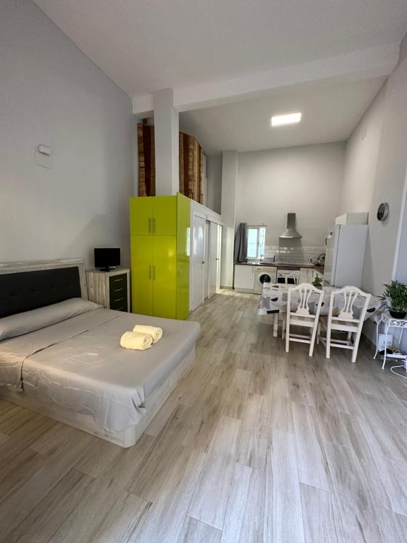 1 dormitorio con 1 cama y cocina con sillas en Apartamentos Redondela en Madrid