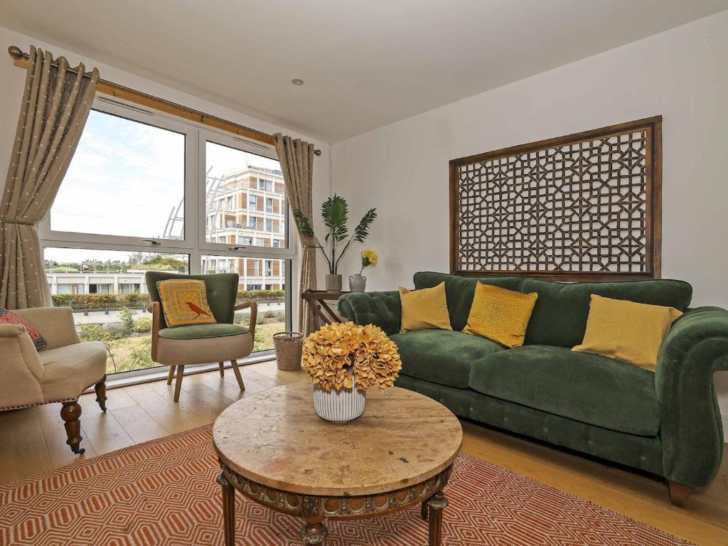 a living room with a green couch and a table at Pass the Keys Stylish comfortable apartment in central Kingston in Kingston upon Thames