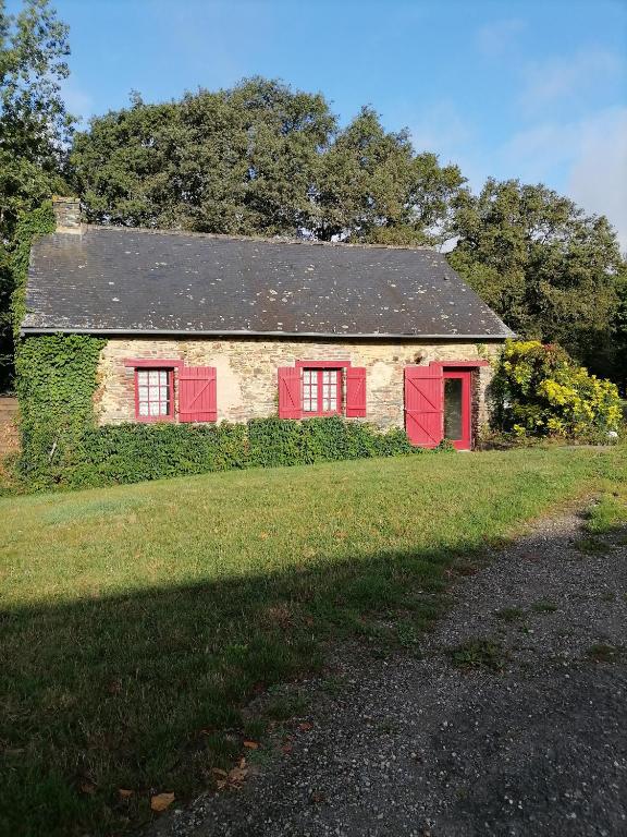une ancienne maison en pierre avec des portes rouges sur un champ dans l'établissement Maison à la campagne 