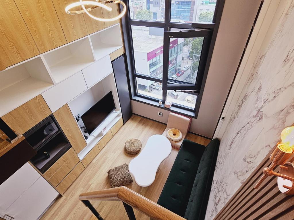 una vista aérea de una sala de estar con sofá y ventana en Luxury Apartment near Lotte World, en Seúl