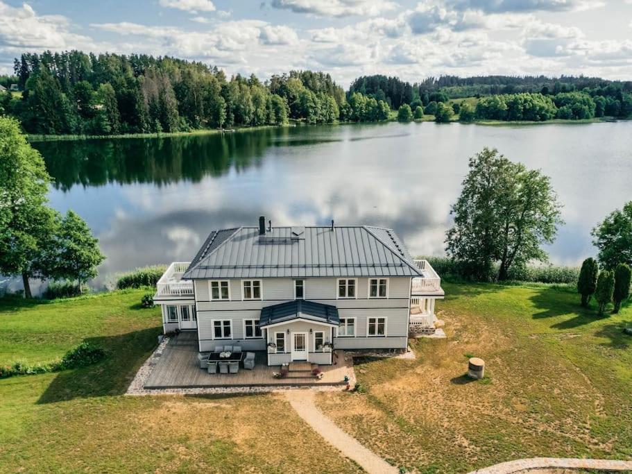 an aerial view of a large house on a lake at Väike-Juusa külaliskorter in Otepää