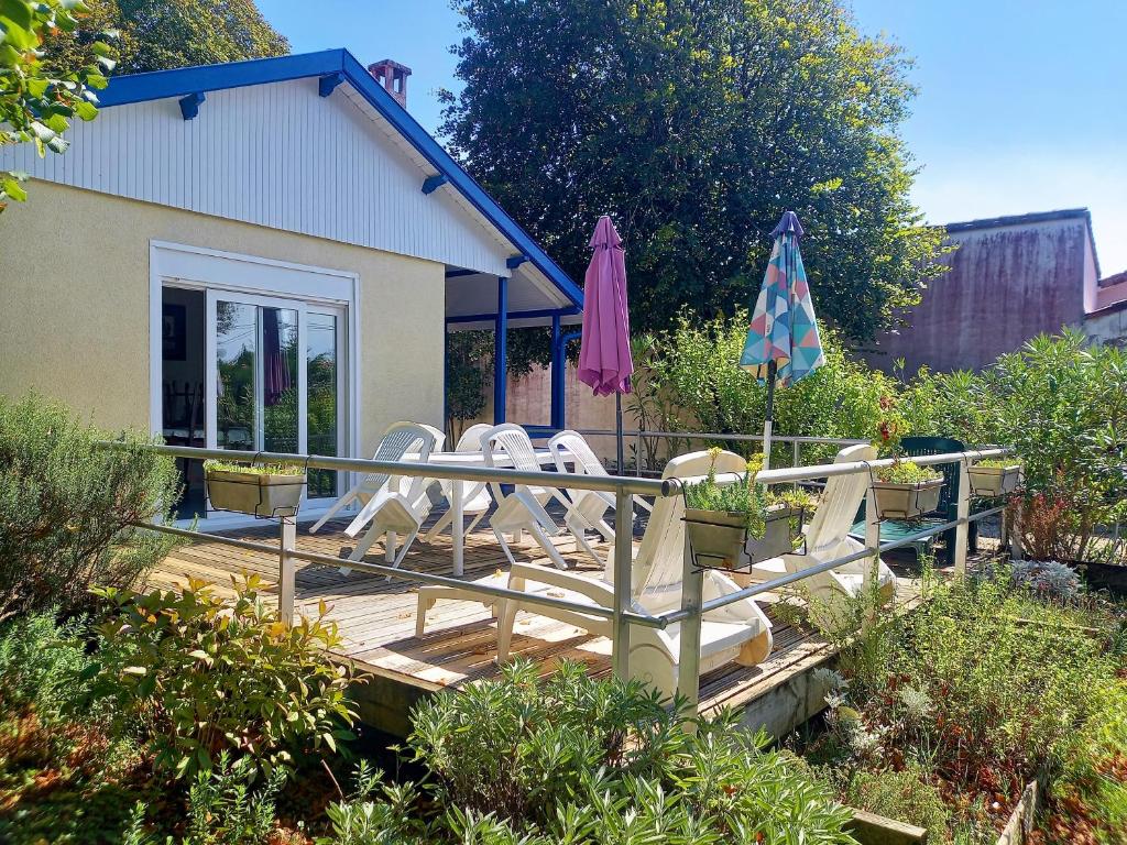 - une terrasse avec des chaises et des parasols dans la cour dans l'établissement Saint Palais sur Mer - MAISON - 10min à pied CENTRE et PLAGE DU BUREAU, à Saint-Palais-sur-Mer