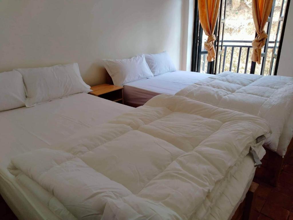 - deux lits assis l'un à côté de l'autre dans une pièce dans l'établissement Hotel Bandipur Bisauni, à Bandipur