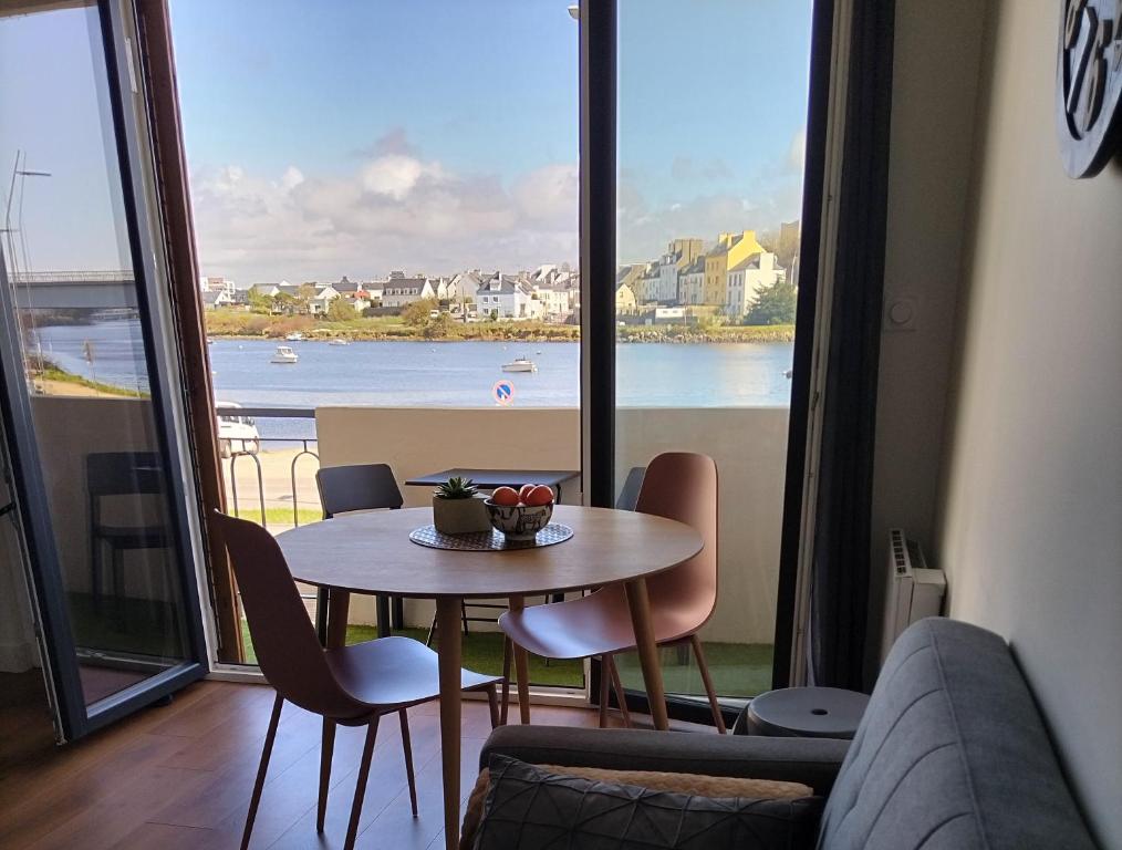 uma sala de jantar com uma mesa e vista para a água em Belle vue Scorff em Lorient