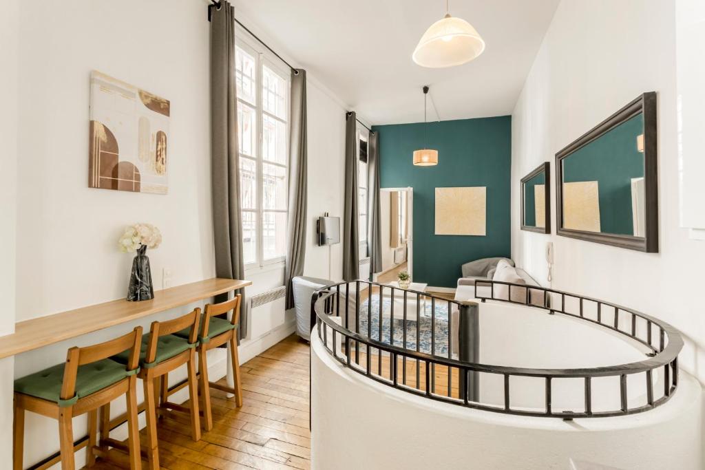 a room with a staircase and a table and chairs at Cosy 3 bedroom duplex apartment with stairs - Louvre in Paris