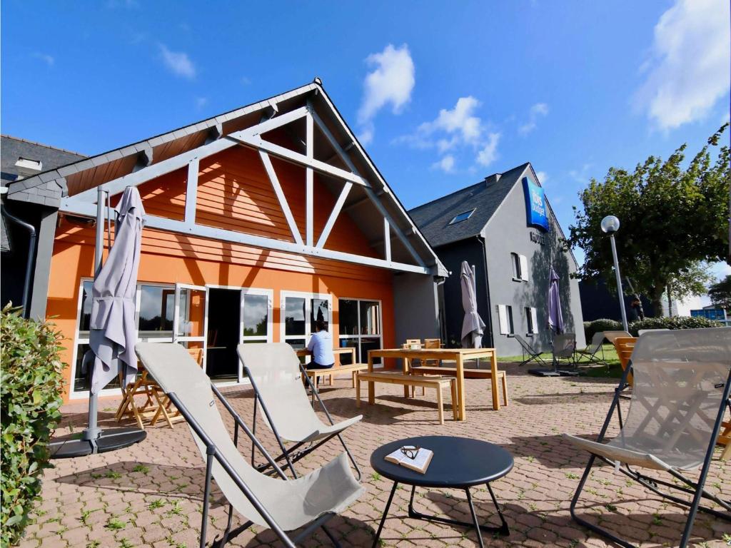 eine Terrasse mit Stühlen und einem Tisch vor einem Haus in der Unterkunft ibis budget Vannes in Vannes