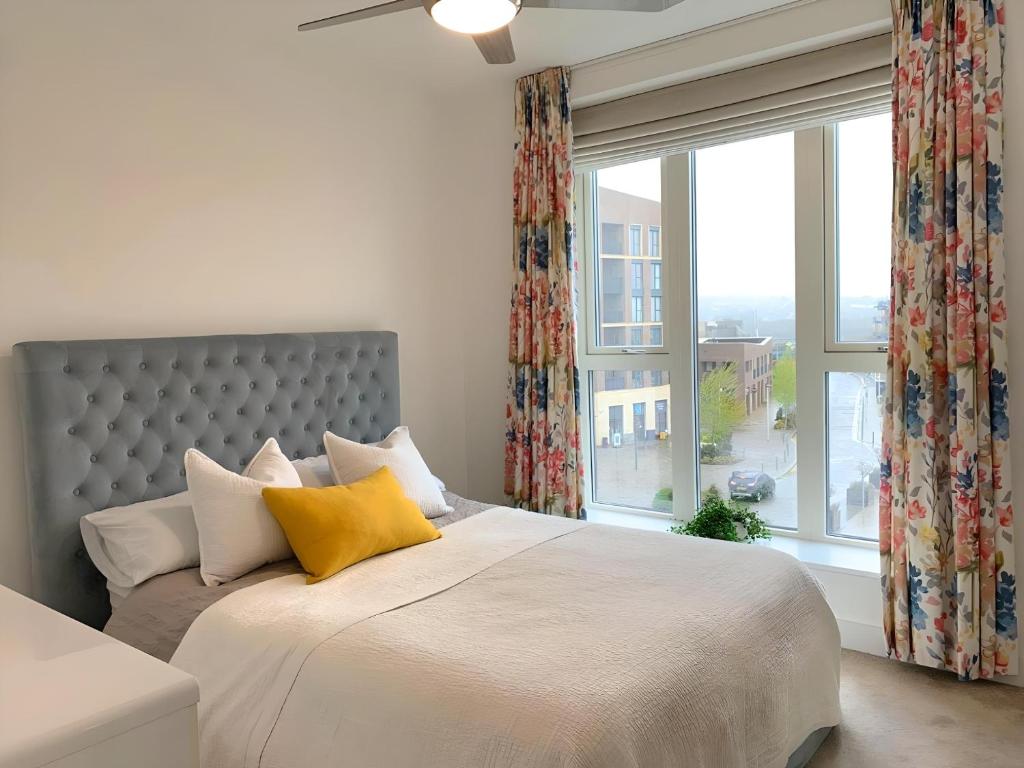 a bedroom with a large bed with yellow pillows and a window at Chic 2 Bed Riverside Retreat in Rochester