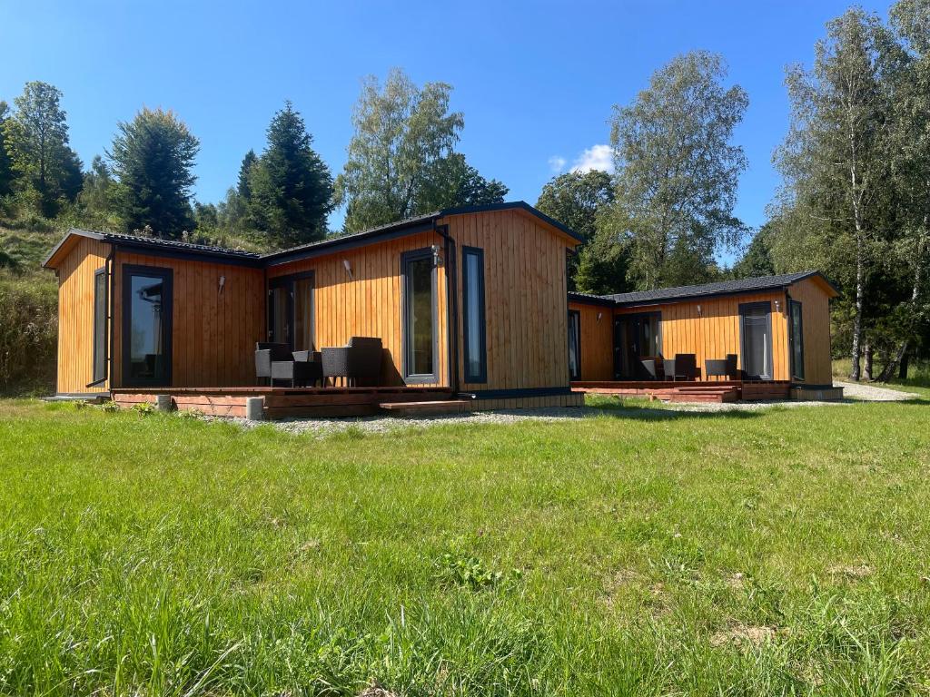 a cabin in a field with a grassy field at VIEW of SMEREK- domki z klimatyzacją in Smerek