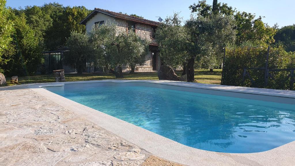 una piscina frente a una casa en La Bandita Cottage, en San Venanzo