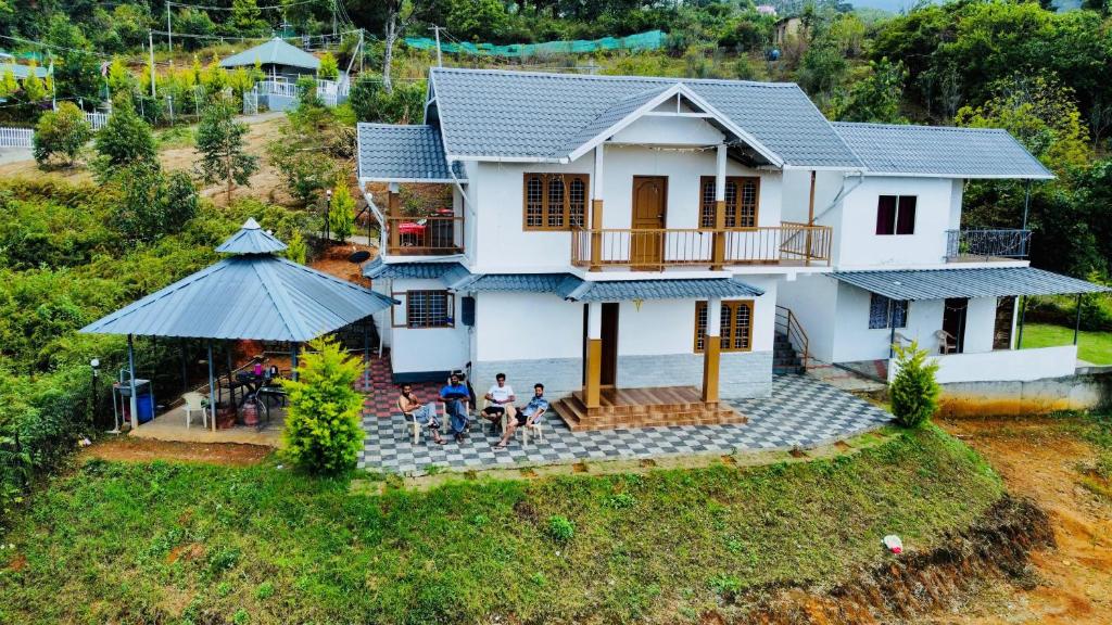 Ein Haus mit Leuten, die draußen stehen. in der Unterkunft Ramstays Valley View Kanthalloor in Kanthalloor