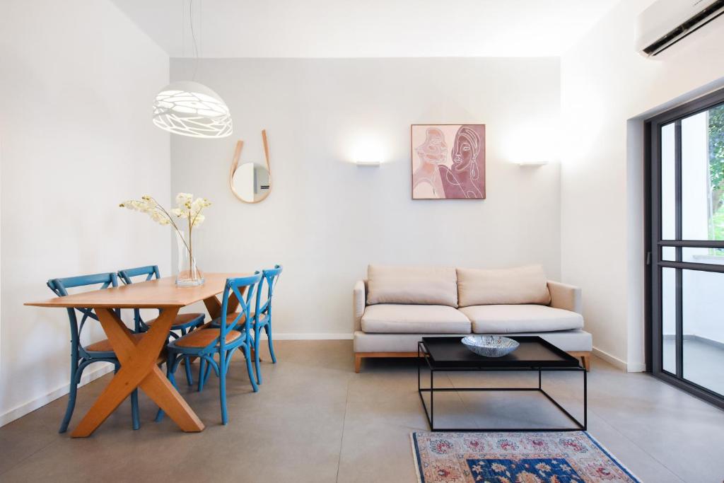 a living room with a table and a couch at Magic Lily by HolyGuest in Tel Aviv